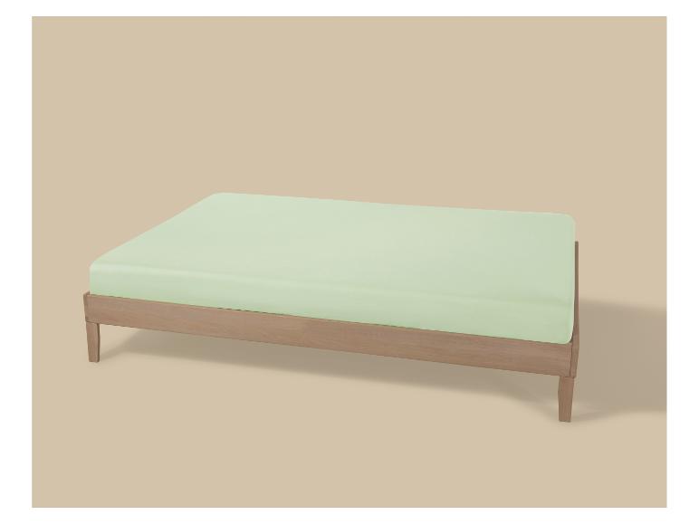 Houten bedframe met een lichtgroen matras