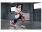 Man in grijs T-shirt en zwarte korte broek doet lunges met een halter.