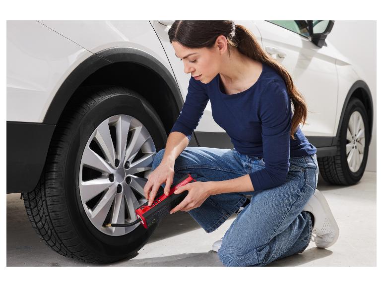 Une femme utilise un gonfleur Ultimate pour pneus de voiture.