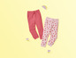 Twee paar joggingbroeken, een roze met watermeloenprint en een effen roze.