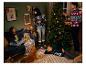 Een gezin in kersttruien versiert een kerstboom.