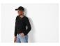 Femme en casquette de baseball noire, pull en maille ajourée noir et jean clair