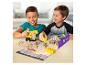 Twee jongens spelen met kinetisch zand, bouwvoertuigen en bouwblokken op een speelmat.