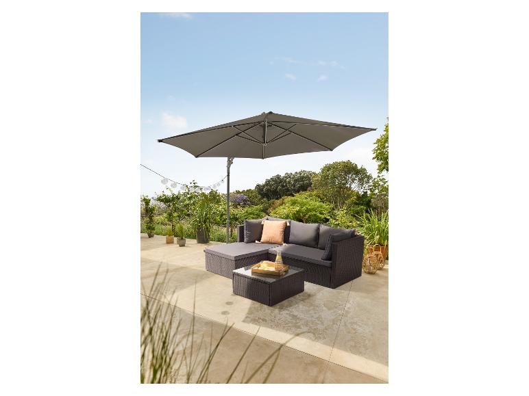 Grijze modulaire tuinbankset met parasol en kussens op een terras.