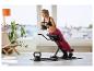 Femme s'entraînant sur un banc d'abdominaux avec un kettlebell de 6 kg, un kettlebell de 8 kg au sol.