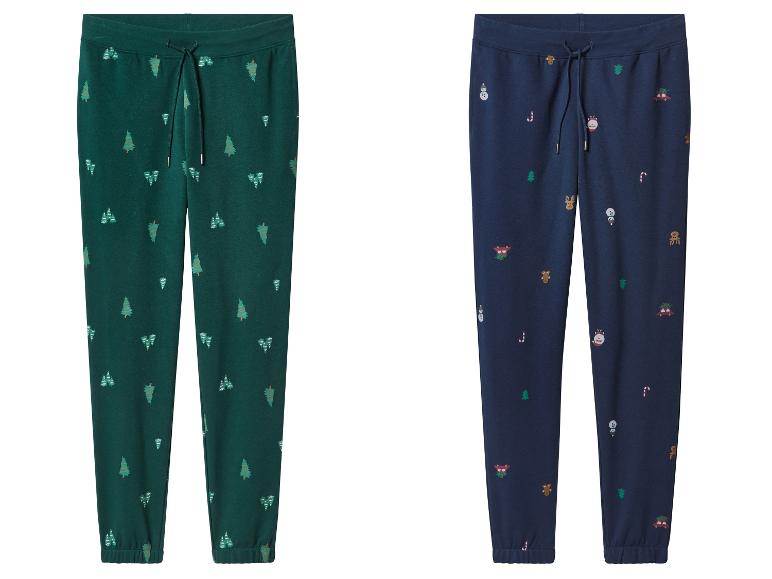 Twee joggingbroeken, één groen met kerstbomen en één blauw met kerstmotieven.