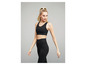 Een vrouw draagt een zwarte sportbeha en legging voor fitness.