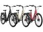 Trois vélos électriques en noir, beige et rose.