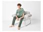 Jongen in olijfgroene pyjama met de tekst 'ATHLETIC 1986' zittend in een fauteuil.