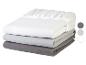 Trois draps-housses gris et blancs pliés en pile, avec bords élastiques.
