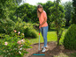 Een vrouw raakt een tuin met een hark glad.