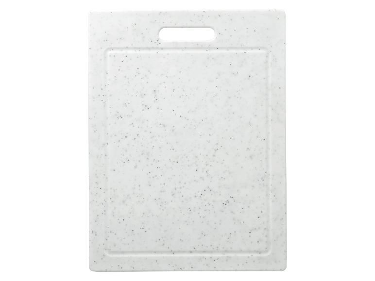 Witte snijplank met zwarte spikkels en uitgesneden handvat