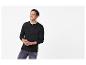 Lachende man in een zwart Henley-shirt met lange mouwen en jeans.