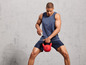 Man in sportkleding met een rode kettlebell van Crivit.