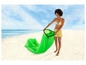 Een vrouw op het strand die een groene opblaasbare loungestoel uitvouwt.