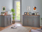Twee grijze dressoirs met houten details in een moderne woonkamer.
