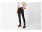 Femme portant une veste beige, un top blanc, un pantalon noir et des baskets noires.