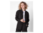 Model in een zwart katoenen pak, broek en overhemd.