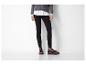 Femme en pull gris, chemise blanche, pantalon noir et mocassins bordeaux.