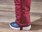 Een donkerrode broek met blauwe laarzen