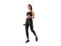Vrouw in zwarte leggings en top die oefent met dumbbells.