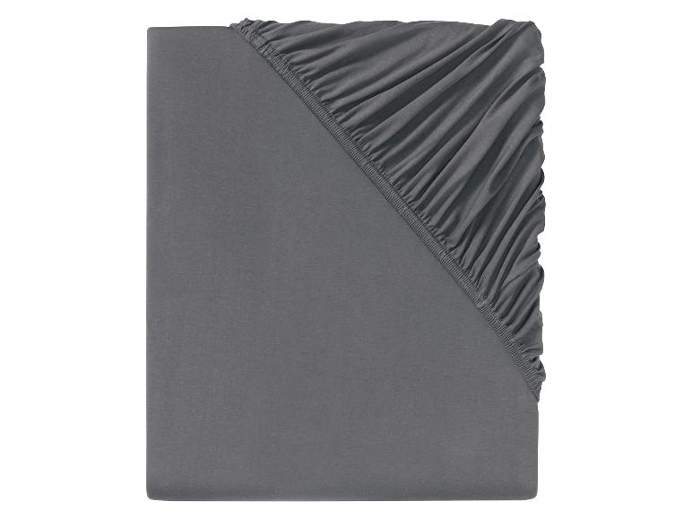 Un drap housse gris avec élastique.