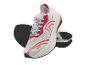 Witte sportschoenen met roze en oranje accenten, van onderaf zichtbaar.