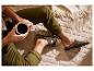 Homme en pantalon vert olive et sandales, buvant du café sur une couverture douillette.