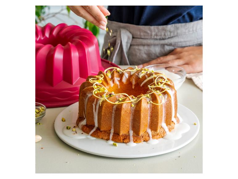 Un gâteau bundt glacé avec des pistaches et du zeste de citron.