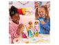 Deux filles jouent avec des poupées et des accessoires Rainbow High.