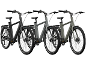 Trois vélos électriques à cadre bas en noir, gris et vert olive.