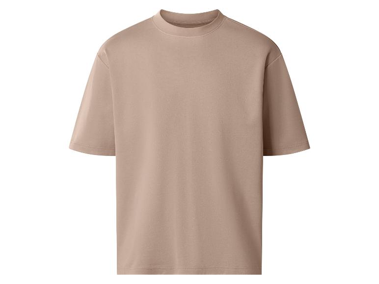 T-shirt beige ample à manches courtes.