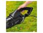 Hand die een zwarte Parkside Performance PPELB 1650 bladblazer met rode knop vasthoudt op groen gras.