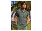 Homme en polo vert imprimé tropical et short vert, debout à l'extérieur