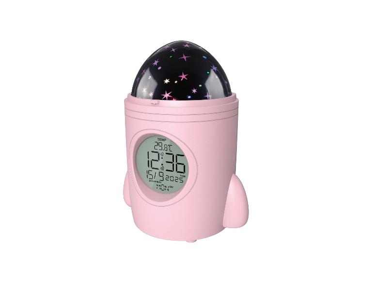 Roze raketvormige wekker met sterrenprojector, die tijd, datum en temperatuur weergeeft.