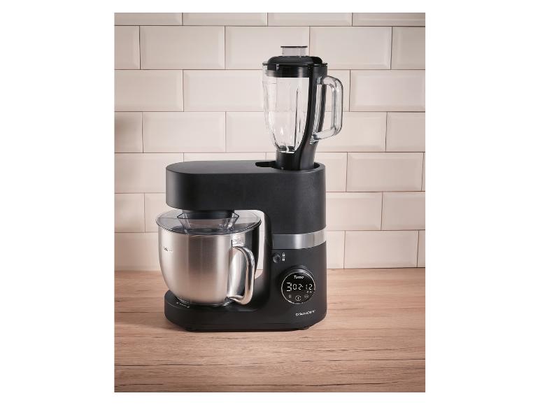 Robot de cuisine noir Silvercrest avec mixeur et bol en acier inoxydable sur un comptoir en bois.