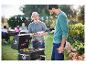 Un homme sert de la viande grillée d'un barbecue Weber.