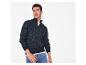 Man in een marineblauwe trui met rits en blauwe jeans.