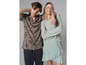 Un homme et une femme posent en tenue décontractée, il porte une chemise rayée et elle une robe verte.