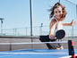 Une femme jouant au tennis de table avec une raquette Butterfly.