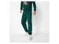 Man in een groene kersttrui en joggingbroek met boompjesprint.
