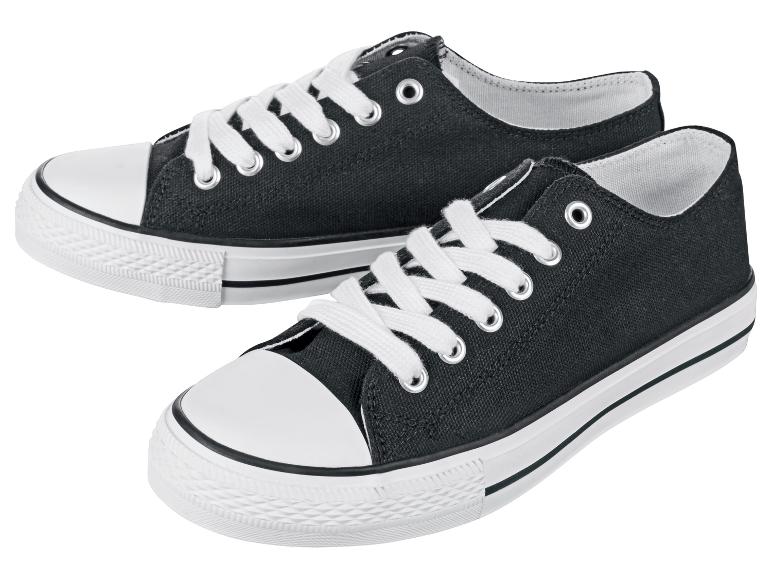 Deux paires de baskets en toile noires avec des lacets blancs.