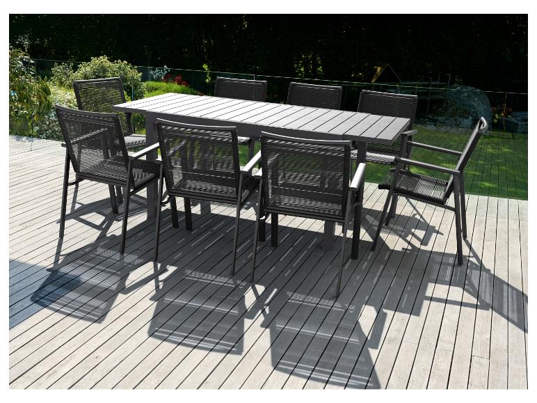 Een zwarte eettafel met stoelen op een houten terras.