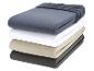 Une pile de quatre draps jersey de différentes couleurs.
