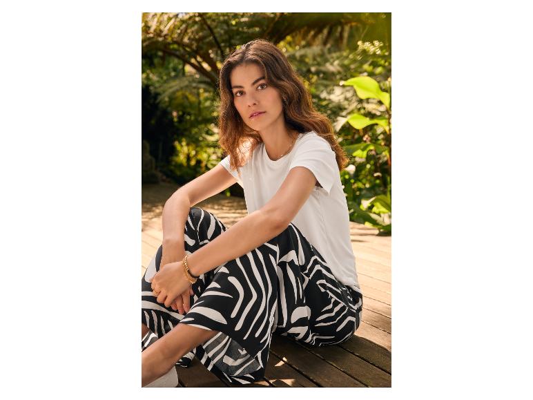 T-shirt blanc et pantalon fluide à motifs zébrés.