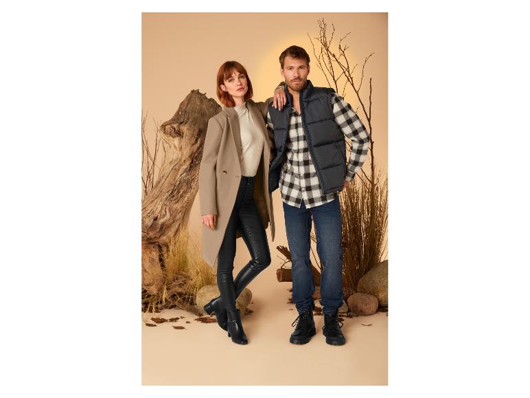 Een man en een vrouw presenteren herfst-/wintermode: een jas, een donsvest en een jeans.