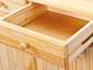Een open lade van een houten kast met een houten handvat.