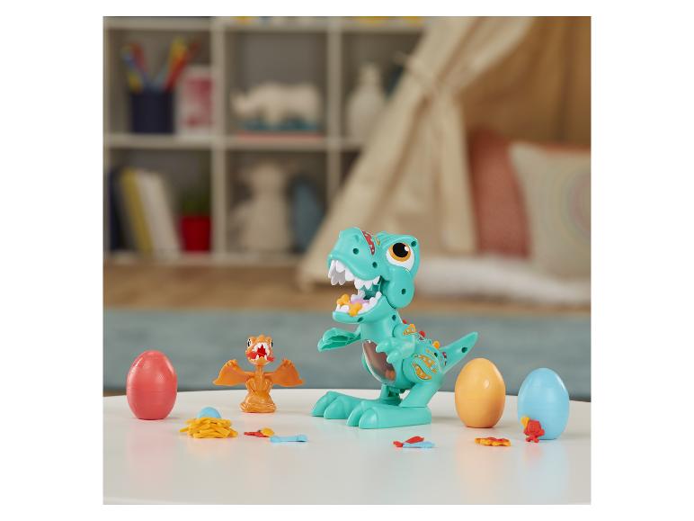 Een groene dinosaurus speelgoedfiguur met eieren en baby dinosaurussen.