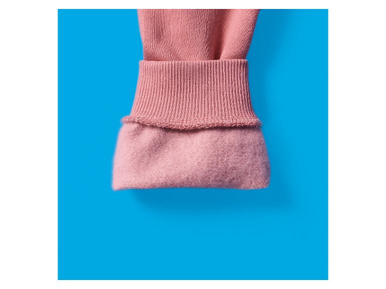 Gros plan d'une manche rose avec un poignet côtelé et une doublure douce.