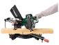 Afkortzaag met stofzak en houten plank, bediend door een gehandschoende hand.